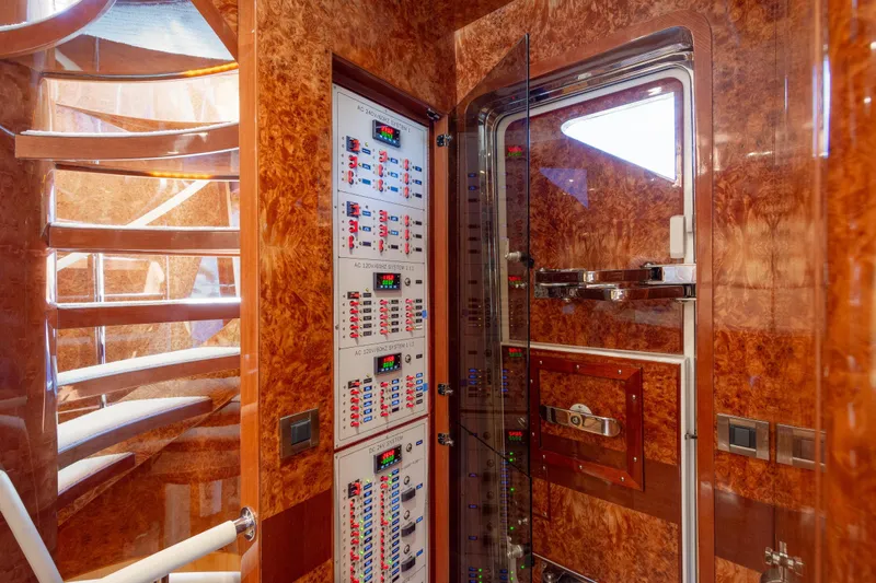 Lucky Penny Yacht Photos Pics Control panel and spiral staircase inside 2014 Hargrave Sky Lounge yacht, featuring wood finish.