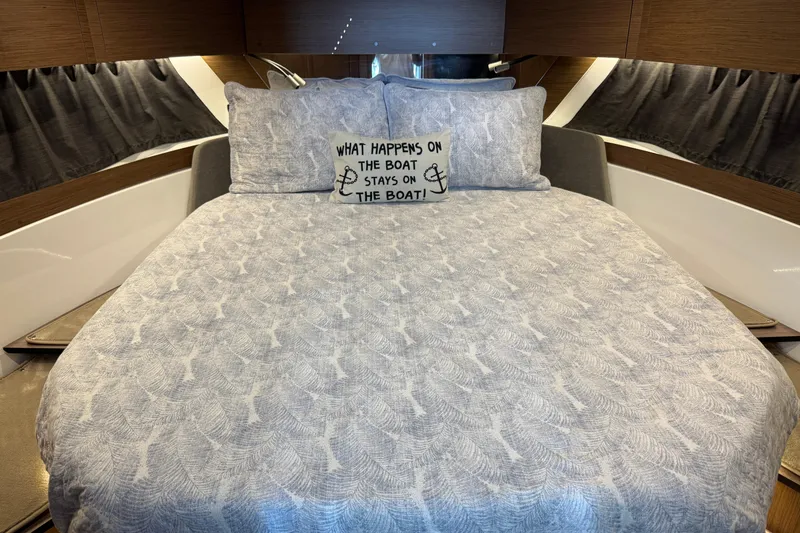  Yacht Photos Pics Cozy bedroom in 2024 Beneteau Antares 11 boat with decorative pillow and elegant bedding.