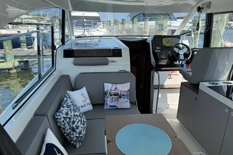  Yacht Photos Pics Interior of 2024 Beneteau Antares 11, featuring modern seating and helm, docked at marina.