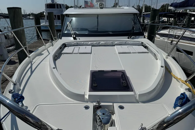  Yacht Photos Pics 2024 Beneteau Antares 11 yacht docked at marina, showcasing spacious deck and sleek design.