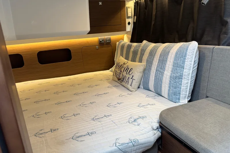  Yacht Photos Pics 2024 Beneteau Antares 11 cabin interior with nautical-themed bedding and cozy decor.