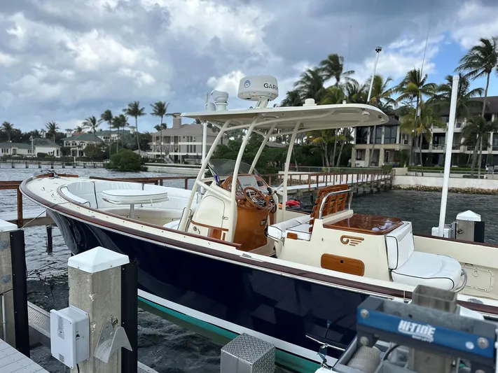 Katie J Yacht Photos Pics 2002 Hinckley Talaria 29 C boat docked by waterfront homes under cloudy skies.