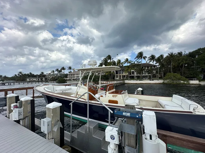 Katie J Yacht Photos Pics 2002 Hinckley Talaria 29 C docked by waterfront homes under cloudy skies.