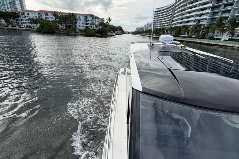 Mj Yacht Photos Pics 2019 Carver C34 yacht cruising through a scenic waterway with modern buildings.