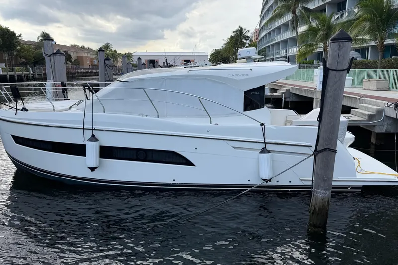 Mj Yacht Photos Pics 2019 Carver C34 yacht docked at marina, sleek design, calm water, overcast sky.
