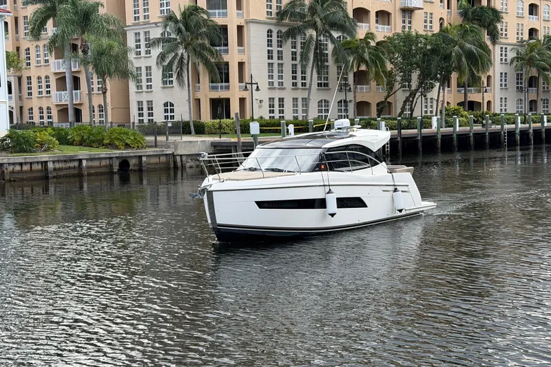 Mj Yacht Photos Pics 2019 Carver C34 yacht cruising near waterfront apartments with palm trees.