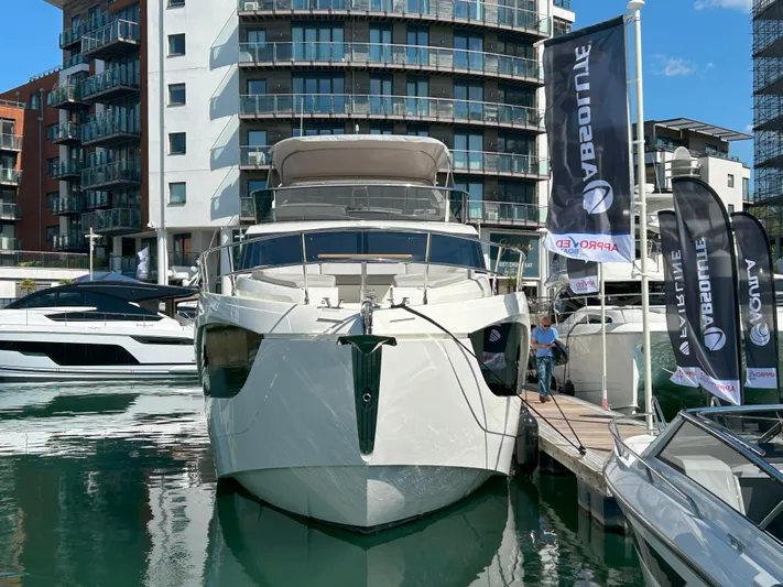 In Stock Yacht Photos Pics Luxury Absolute 47 Fly yacht docked at marina, 2025 model, with modern buildings in background.