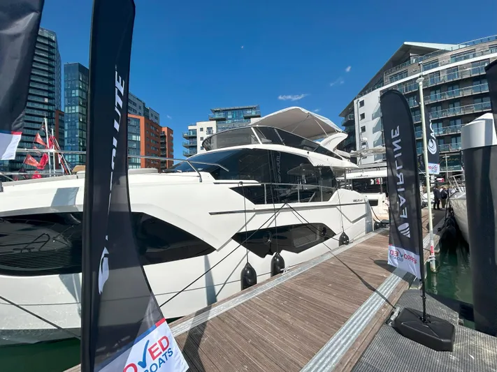 In Stock Yacht Photos Pics Luxury Absolute 47 Fly yacht docked at marina, 2025 model, with modern architecture backdrop.