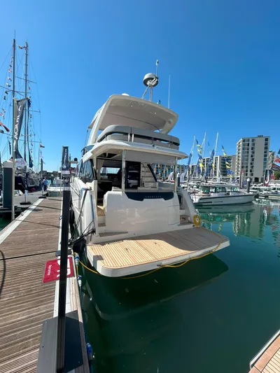 In Stock Yacht Photos Pics 2025 Absolute 47 Fly yacht docked at marina, clear blue sky, modern design.