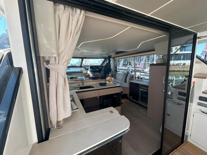 In Stock Yacht Photos Pics Luxurious interior of 2025 Absolute 47 Fly yacht with modern kitchen and seating area.