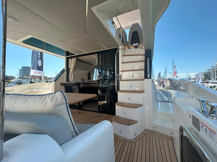 In Stock Yacht Photos Pics Luxurious 2025 Absolute 47 Fly yacht interior with elegant seating and wooden stairs.