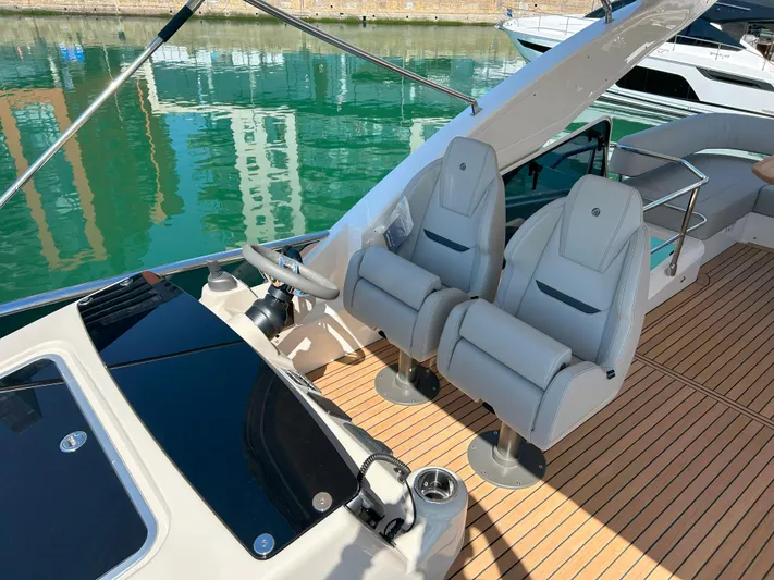 In Stock Yacht Photos Pics Luxury seating on 2025 Absolute 47 Fly yacht with sleek design and waterfront view.