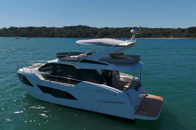 In Stock Yacht Photos Pics 2025 Absolute 47 Fly yacht cruising on serene blue waters.