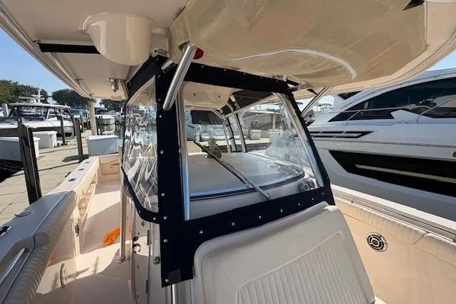  Yacht Photos Pics 2013 Grady-White Canyon 336 boat interior, featuring seating and helm area at a marina.