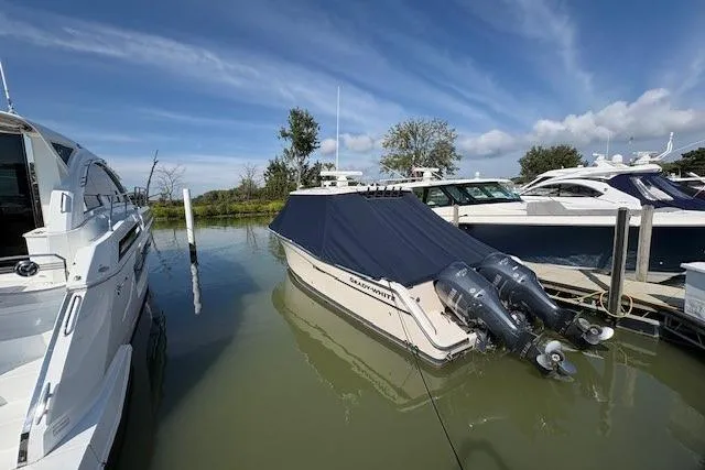  Yacht Photos Pics 2013 Grady-White Canyon 336 boat docked with cover, twin outboard engines, clear sky.