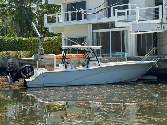  Yacht Photos Pics 2022 Sea Fox 328 Commander boat docked by a modern waterfront house.