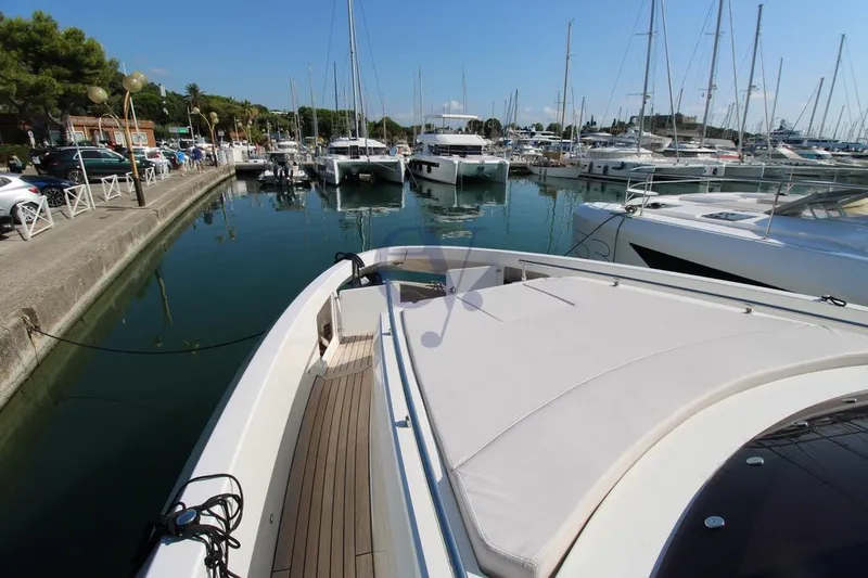 L Yacht Photos Pics 2023 MandaYachts Manda S05 docked in a marina, surrounded by other boats.
