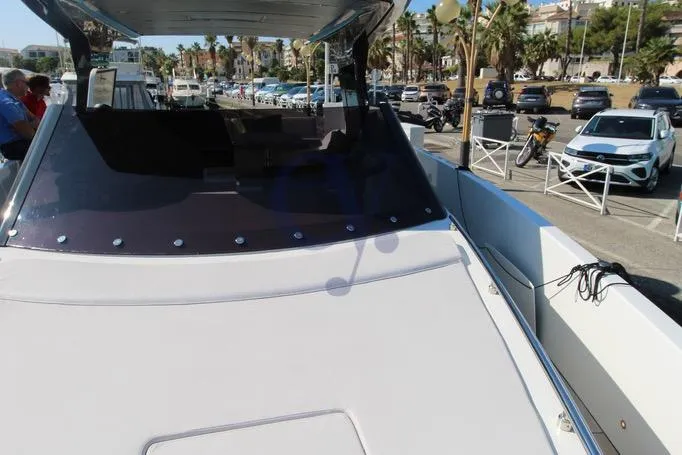 L Yacht Photos Pics 2023 MandaYachts Manda S05 yacht docked at marina with cars and palm trees in background.