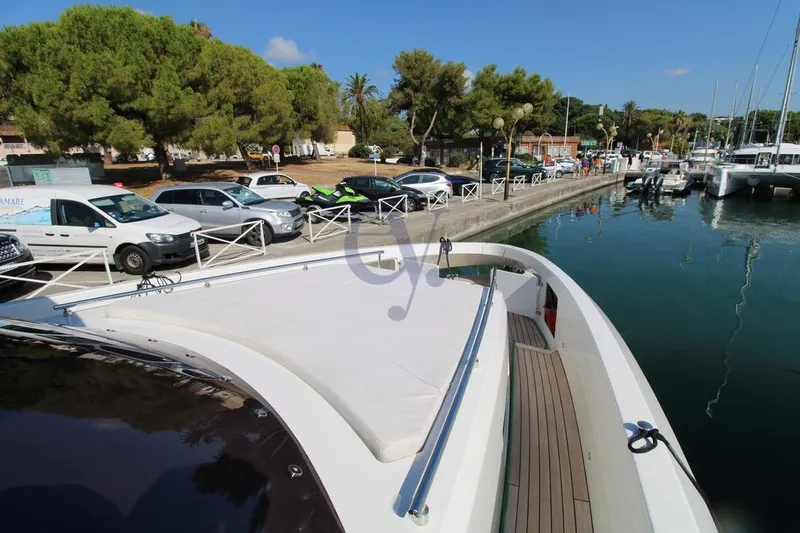 L Yacht Photos Pics 2023 MandaYachts Manda S05 docked at a marina with parked cars nearby.