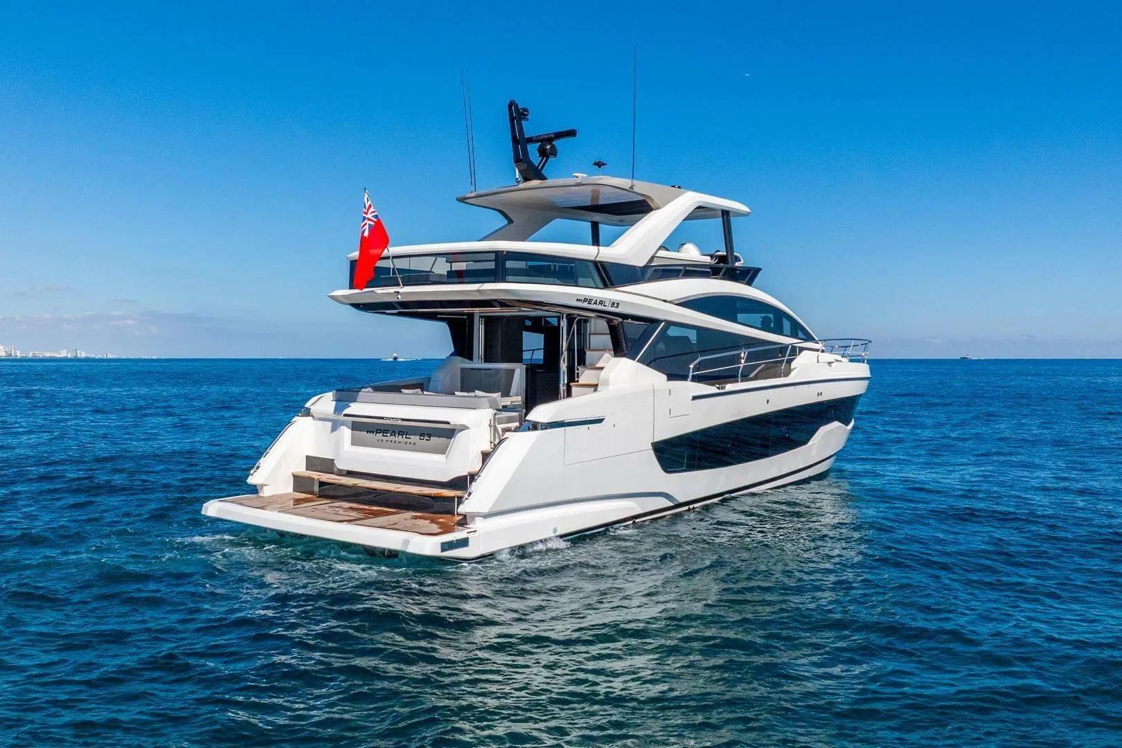 Luxury Pearl 63 yacht cruising on open sea, 2025 model, under clear blue sky.