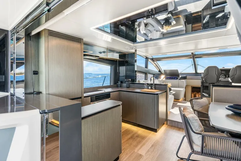  Yacht Photos Pics Luxurious interior of 2025 Pearl 63 yacht with modern kitchen and seating area.