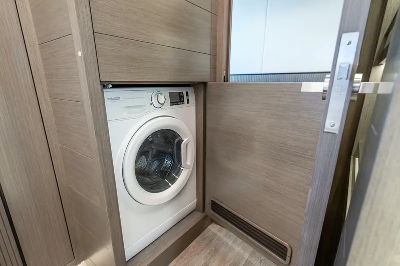  Yacht Photos Pics Compact laundry area in Pearl 63, 2025 model, featuring a built-in washing machine.