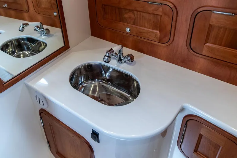 Golightly Yacht Photos Pics 2023 Hinckley Picnic Boat 34 S bathroom with sleek sink and wooden cabinetry.