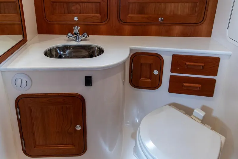 Golightly Yacht Photos Pics 2023 Hinckley Picnic Boat 34 S bathroom with wooden cabinetry and modern fixtures.