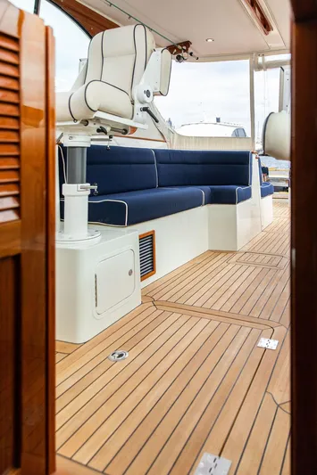 Golightly Yacht Photos Pics 2023 Hinckley Picnic Boat 34 S interior with wooden flooring and blue seating.