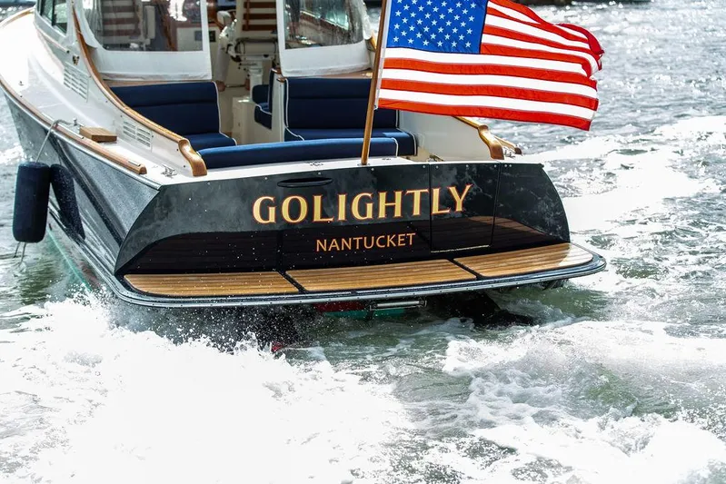 Golightly Yacht Photos Pics 2023 Hinckley Picnic Boat 34 S with American flag, named "Golightly," cruising in Nantucket waters.