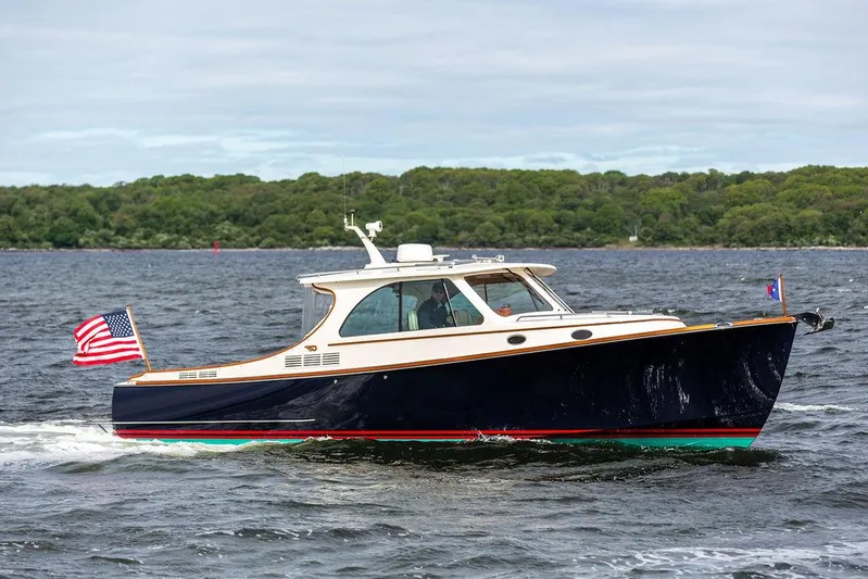 Golightly Yacht Photos Pics 2023 Hinckley Picnic Boat 34 S cruising on a lake with an American flag.