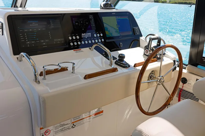 In Stock Yacht Photos Pics Helm of 2026 MJM 47X yacht with advanced navigation displays and wooden steering wheel.