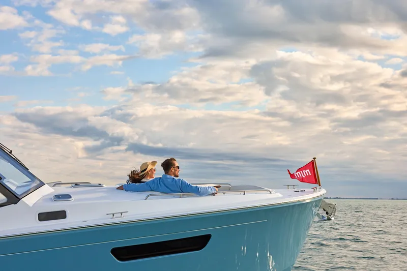 In Stock Yacht Photos Pics Couple relaxing on MJM 47X yacht, 2026 model, under a cloudy sky.