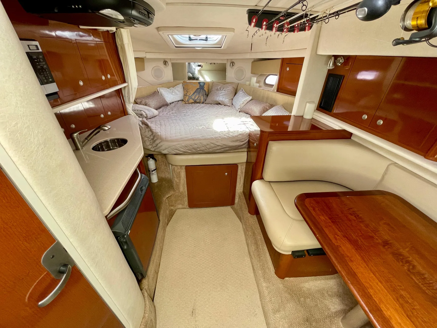 2005 Sea Ray Amberjack 290 cabin interior with bed, kitchenette, and dining area.