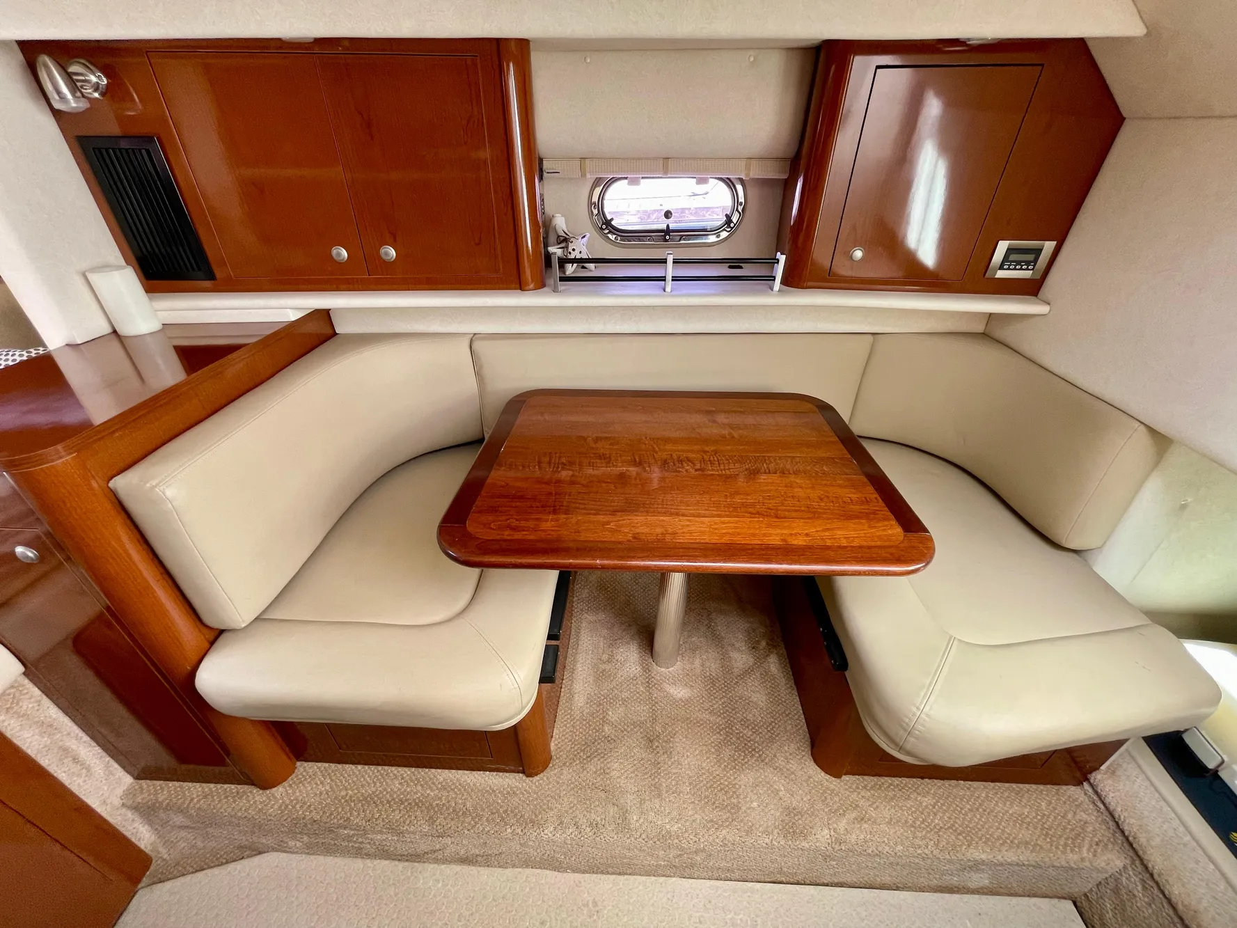 2005 Sea Ray Amberjack 290 interior with beige seating and wooden table.