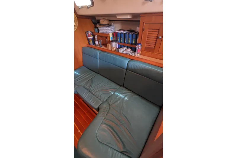 Mawe Yacht Photos Pics Interior of 2006 Island Packet 440 yacht with green leather seating and wooden shelves.