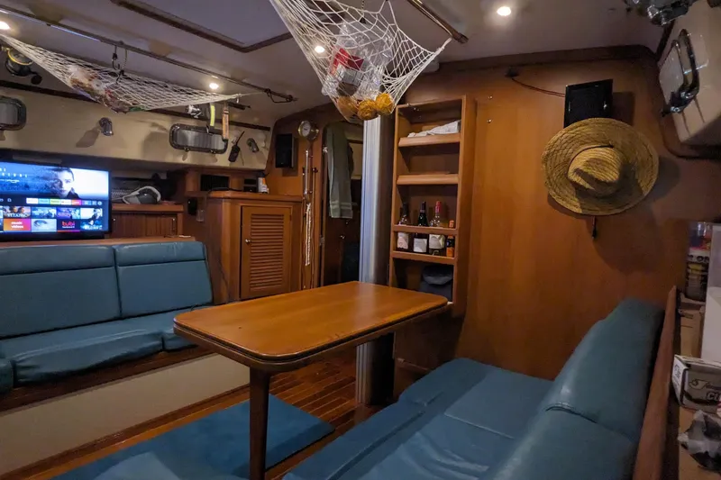 Mawe Yacht Photos Pics Interior of 2006 Island Packet 440 yacht with cozy seating, wooden table, and entertainment system.