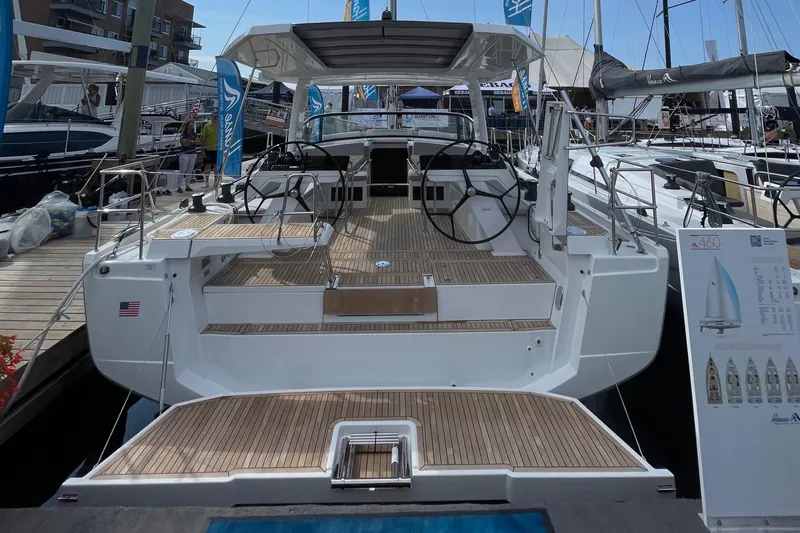 Uncorked Yacht Photos Pics 2023 Hanse 460 yacht with spacious deck and dual steering wheels at a marina.
