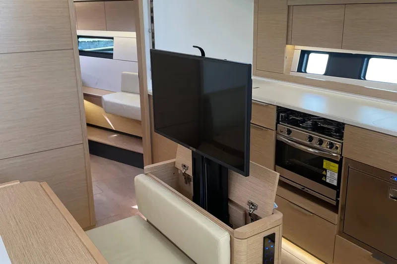 Uncorked Yacht Photos Pics Modern interior of 2023 Hanse 460 yacht with TV, kitchen, and seating area.