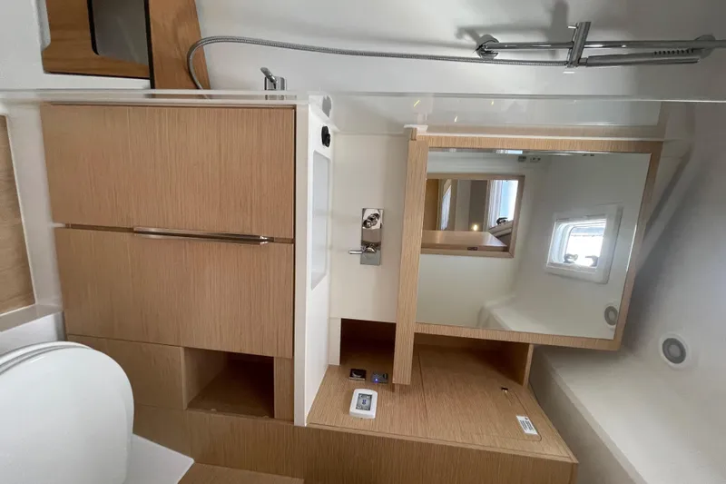 Uncorked Yacht Photos Pics Modern bathroom interior of 2023 Hanse 460 yacht with wooden cabinetry and mirror.