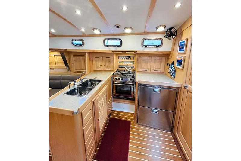Stargazer Yacht Photos Pics Luxurious 2019 Tartan 395 yacht interior kitchen with modern appliances and wooden cabinetry.