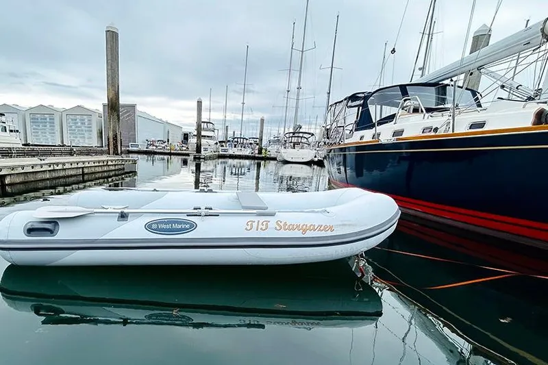 Stargazer Yacht Photos Pics Inflatable boat "TIS Stargazer" docked near Tartan 395 yacht, 2019 model, in marina.