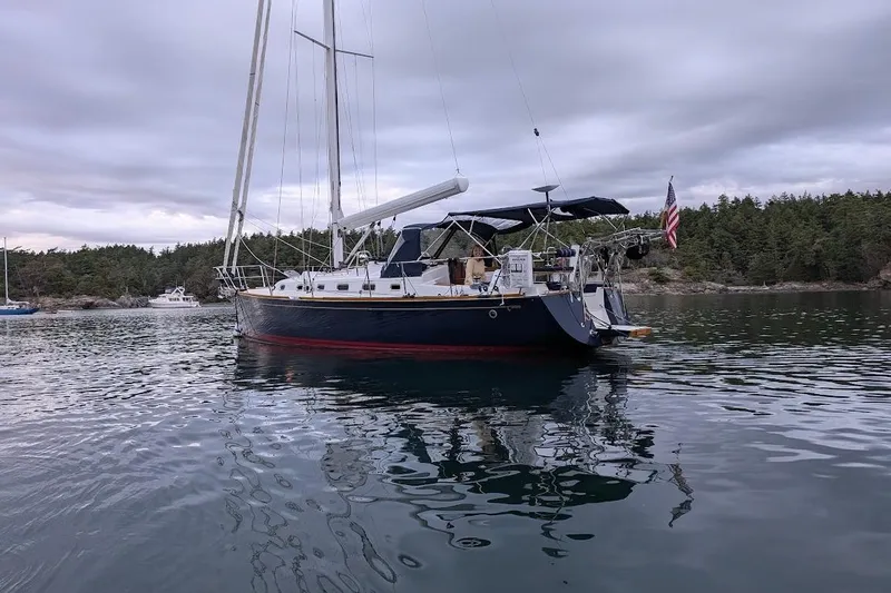 Stargazer Yacht Photos Pics Sailboat Tartan 395, 2019 model, anchored in a scenic bay with forested shoreline.