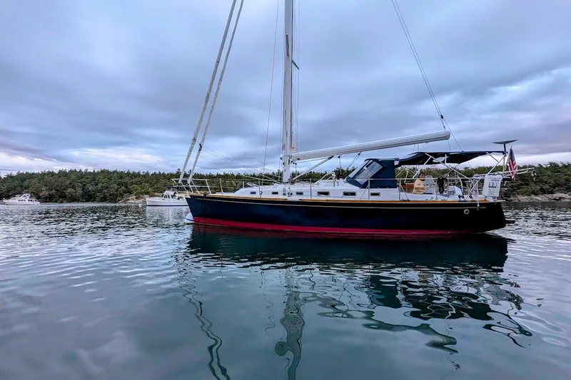Stargazer Yacht Photos Pics Sailboat on calm water, Tartan 395, 2019 model, with scenic forest backdrop.