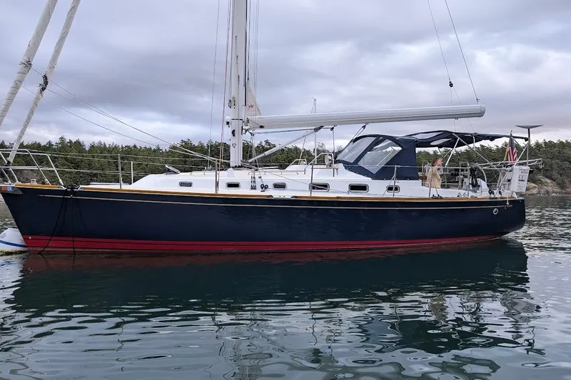Stargazer Yacht Photos Pics Sailboat Tartan 395, 2019 model, anchored on calm water with forested background.