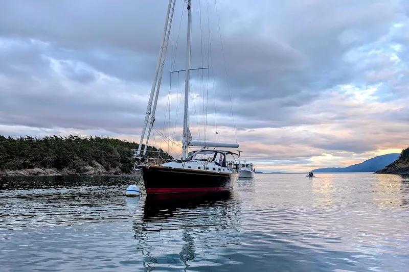 Stargazer Yacht Photos Pics Sailboat Tartan 395 (2019) anchored in scenic coastal waters at sunset.