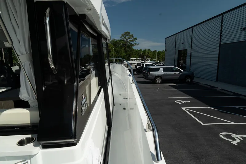 38 Explorer Yacht Photos Pics 2025 Wellcraft 355 yacht docked near a parking lot, showcasing sleek design and modern features.