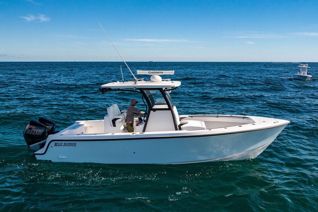 2026 Reef Runner 280 boat cruising on open ocean under clear blue sky.