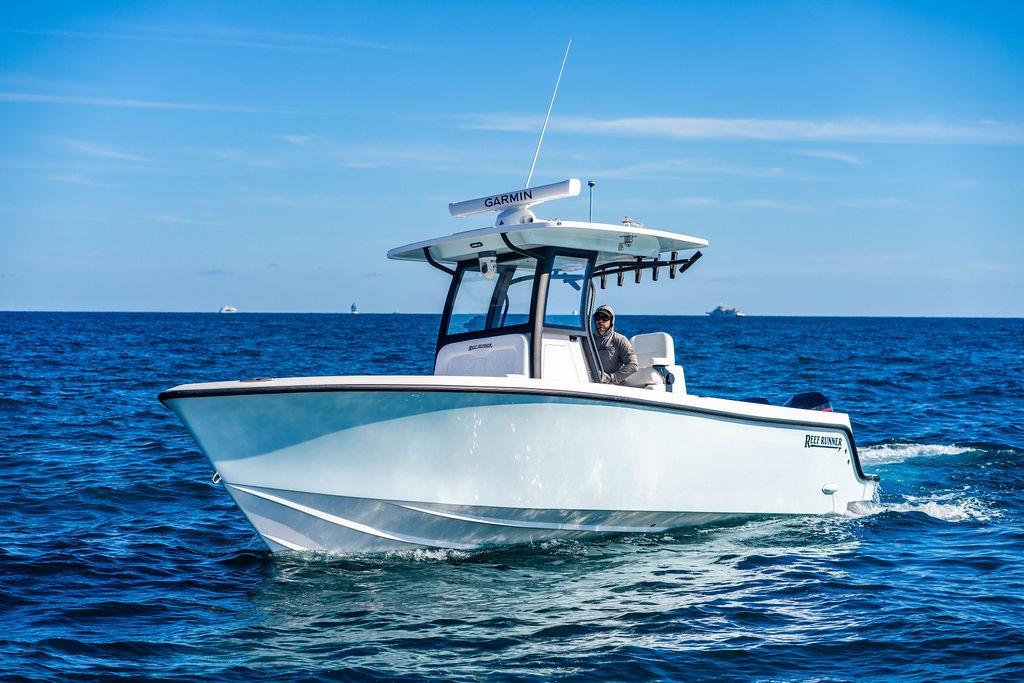 2026 Reef Runner 280 boat cruising on open ocean under clear blue sky.