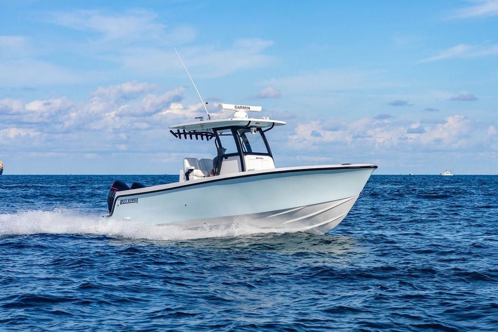 2026 Reef Runner 280 boat cruising on open ocean under clear blue sky.